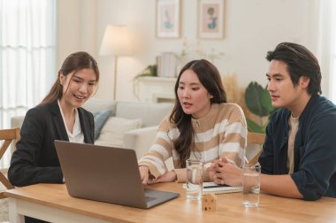 Asyalı finans danışmanı ofisteki genç çifte yeni proje yatırımını açıklıyor. Emlakçı aileyle ipotek seçeneklerini tartışıyor. Finans danışmanıyla ipotek kredisi danışmanlığı.