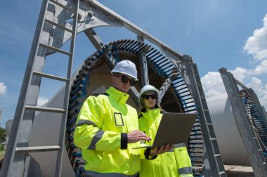 Rüzgâr türbini bakım ve onarım teknisyeni, mühendis türbinleri kontrol ediyor. Rüzgar türbini çiftliğinde bakım ve temiz güç jeneratörü sistemi çalışıyor.