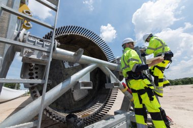Rüzgâr türbini bakım ve onarım teknisyeni, mühendis türbinleri kontrol ediyor. Rüzgar türbini çiftliğinde bakım ve temiz güç jeneratörü sistemi çalışıyor.