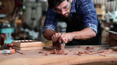 Luthier ahşap müzikal yapıyor ve çalışma odasında el aletleriyle geleneksel aletler kullanıyor.