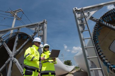 Rüzgâr türbini bakım ve onarım teknisyeni, mühendis türbinleri kontrol ediyor. Rüzgar türbini çiftliğinde bakım ve temiz güç jeneratörü sistemi çalışıyor.