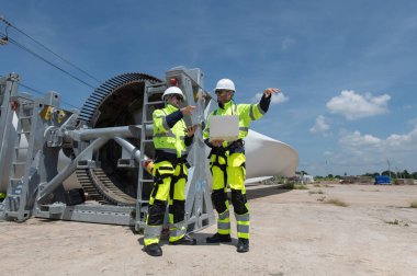 Rüzgâr türbini bakım ve onarım teknisyeni, mühendis türbinleri kontrol ediyor. Rüzgar türbini çiftliğinde bakım ve temiz güç jeneratörü sistemi çalışıyor.