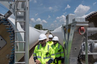 Rüzgâr türbini bakım ve onarım teknisyeni, mühendis türbinleri kontrol ediyor. Rüzgar türbini çiftliğinde bakım ve temiz güç jeneratörü sistemi çalışıyor.