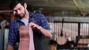 Luthier, el aletleri, sanat ve el sanatları konseptiyle çalışma odasında geleneksel aletleri kullanarak gitarın tepesini yapıyor.