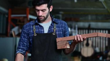 Luthier, el aletleri, sanat ve el sanatları konseptiyle çalışma odasında geleneksel aletleri kullanarak gitarın tepesini yapıyor.