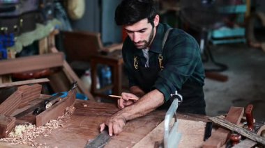 Luthier, el aletleri, sanat ve el sanatları konseptiyle çalışma odasında geleneksel aletleri kullanarak gitarın tepesini yapıyor.