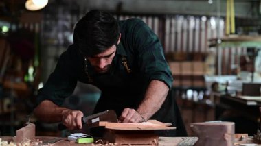 Luthier ahşap müzikal yapıyor ve çalışma odasında el aletleriyle geleneksel aletler kullanıyor.
