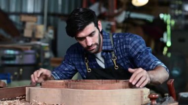 Luthier ahşap müzikal yapıyor ve çalışma odasında el aletleriyle geleneksel aletler kullanıyor.