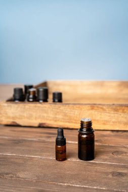 Gerekli yağlar gri arka planda küçük cam şişelerde. Seçici odak ve metin için alanı kopyala. Doğal kozmetik ürünleri.