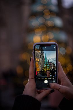 Bordeaux 'daki cam ve çelik Noel ağacının fotoğrafını çeken bir kadın. Telefonu, kişisel bakış açısı, Bordeaux, Fransa