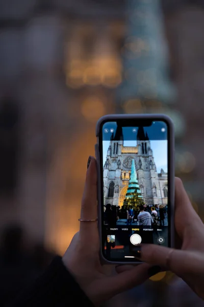 stock image Woman taking a picture of the glass and steel Christmas tree in Bordeaux with her phone, personal perspective, Bordeaux, France