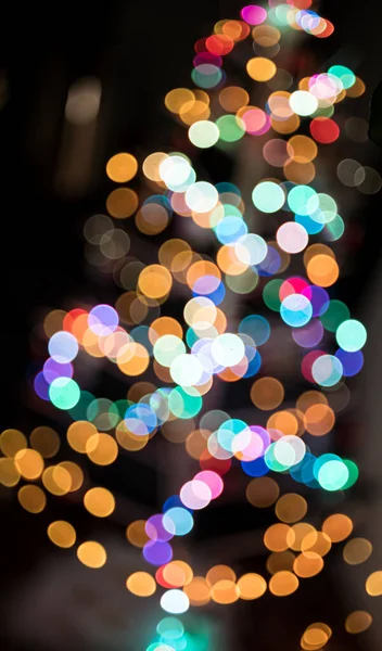 Defokussiertes Bild Eines Beleuchteten Weihnachtsbaums Vor Schwarzem Hintergrund — Stockfoto