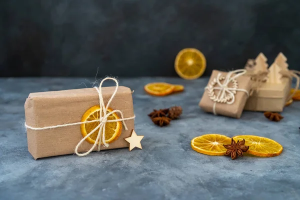 Zero waste Christmas concept. Eco-friendly kraft paper wrapping gifts on a slate table. DIY gifts, eco decor. Copy space, banner.