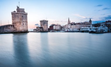 Gün batımında La Rochelle Limanı. Panorama silueti. La Rochelle 'in ünlü kuleleri yılbaşı ışıklarıyla aydınlanır..