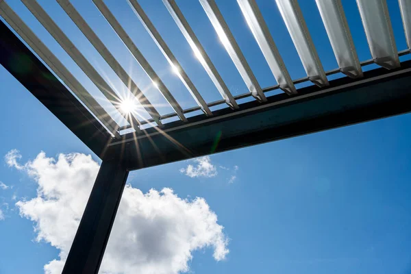 トレンディな屋外パティオペルゴラ 太陽の光は金属構造を通過し ロイヤリティフリーのストック写真