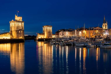 La Rochelle 'in eski limanının aydınlatılmış güzel şehri gece karanlığında şenlikli ciyiliklerle