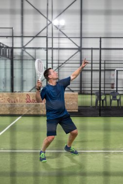 Padel Tenis Oyuncusuyla Raket Elde. Kürek tenisi, yeşil arka planda..