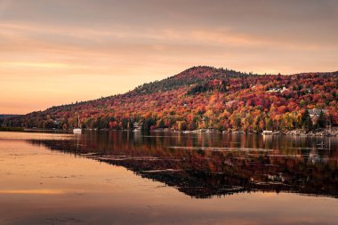 Renkli bir sonbahar akşamı göle yansıyor. Dağ gölünde renkli sonbahar günbatımı. Renkli sonbahar manzarası. Parc national Mont Tremblant. Quebec 'te. Kanada 'da sonbahar