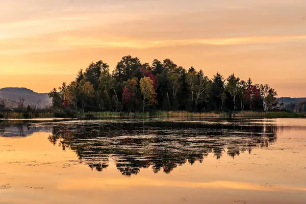 Renkli bir sonbahar akşamı göle yansıyor. Dağ gölünde renkli sonbahar günbatımı. Renkli sonbahar manzarası. Parc national Mont Tremblant. Quebec 'te. Kanada 'da sonbahar