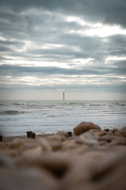 Chauveau lighthouse, isle of Re, at sunrise on a wavy sea. clipart