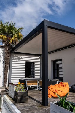 gerçekçi fotoğraf modern tasarım alüminyum levhalar ile biyolimatik pergola yüzme havuzu olan, yemek alanı bol, bitki örtüsü olan modern bir evin yanında duruyor.