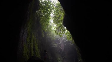 Ormanın ortasında mağarada bir kadın. Bali, Endonezya. Yüksek kaliteli FullHD yavaş çekim görüntüleri.