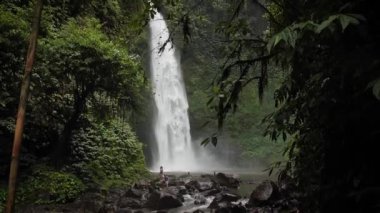 Ormanın ortasında kocaman bir Nungnung şelalesi. Bali, Endonezya. Yüksek kaliteli FullHD yavaş çekim görüntüleri.