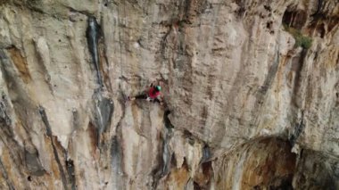 Yunanistan 'ın Kalymnos adasındaki dik bir duvarda zorlu bir tırmanış rotasına tırmanan güçlü bir dağcı. Yüksek kalite 4k görüntü.