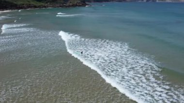 Playa de Los Locos, Cantabria, İspanya 'daki sörfçülerin 4K hava aracı görüntüleri. Yüksek kalite 4k görüntü
