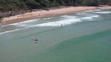 Playa de Los Locos, Cantabria, İspanya 'daki sörfçülerin 4K hava aracı görüntüleri. Yüksek kalite 4k görüntü