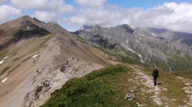 Arkasında la Meije zirvesi olan genç bir kadının Alplerde yürüdüğü 4K Drone görüntüleri. Yüksek kalite 4k görüntü