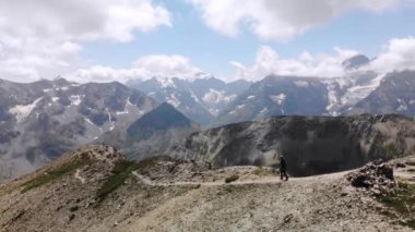 Arkasında la Meije zirvesi olan genç bir kadının Alplerde yürüdüğü 4K Drone görüntüleri. Yüksek kalite 4k görüntü