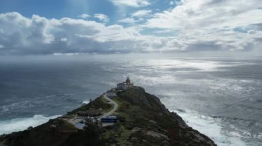 İspanya 'nın Galiçya şehrinde gün batımında Finisterre deniz fenerinin insansız hava aracı görüntüleri. Yüksek kalite 4k görüntü