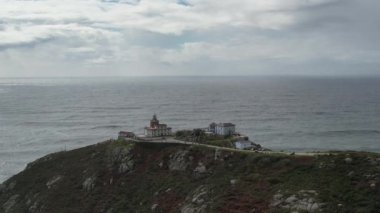 İspanya 'nın Galiçya şehrinde gün batımında Finisterre deniz fenerinin insansız hava aracı görüntüleri. Yüksek kalite 4k görüntü