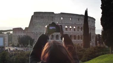Roma, İtalya 'da gün batımında Roma Stadyumu' nda fotoğraf çeken bir kadın. Yüksek kaliteli ağır çekim FullHD görüntüler