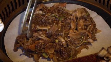 Şef Kore barbeküsünde baharatlı yemek ve sebze pişiriyor. Yüksek kalite 4k görüntü