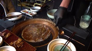 Şef Kore barbeküsünü tipik ve baharatlı olarak bitiriyor. Yüksek kalite 4k görüntü