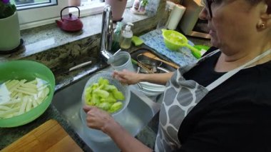 Ev hanımı mutfağında marul yıkıyor. Yüksek kalite 4k görüntü