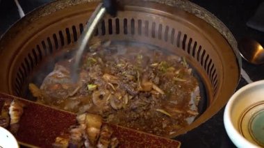 Şef Kore barbeküsünde baharatlı yemek ve sebze pişiriyor. Yüksek kalite 4k görüntü