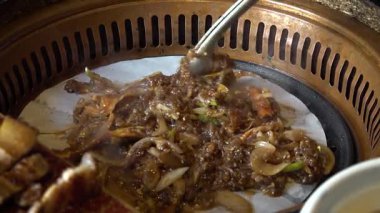 Şef Kore barbeküsünde baharatlı yemek ve sebze pişiriyor. Yüksek kalite 4k görüntü