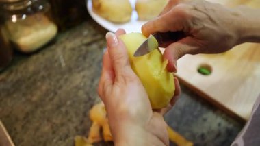 Ev hanımı evlerinin mutfağında patates soyup kesiyor. Yüksek kalite 4k görüntü