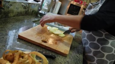  Ev hanımı evlerinin mutfağında patates soyup kesiyor. Yüksek kalite 4k görüntü