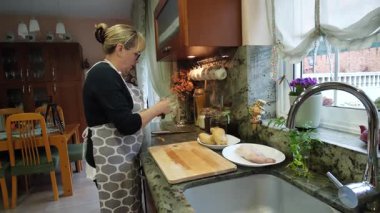  Ev hanımı evlerinin mutfağında patates soyup kesiyor. Yüksek kalite 4k görüntü