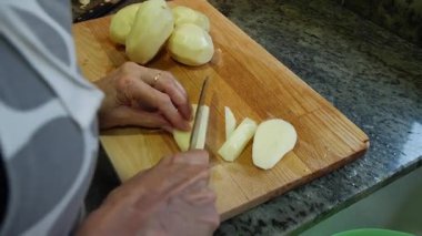  Ev hanımı evlerinin mutfağında patates soyup kesiyor. Yüksek kalite 4k görüntü