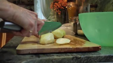  Ev hanımı evlerinin mutfağında patates soyup kesiyor. Yüksek kalite 4k görüntü