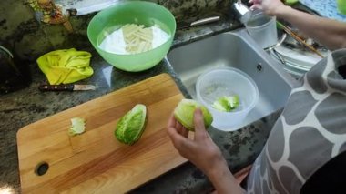 Ev hanımı mutfağında marul yıkıyor. Yüksek kalite 4k görüntü