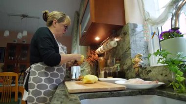  Ev hanımı evlerinin mutfağında patates soyup kesiyor. Yüksek kalite 4k görüntü