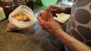  Ev hanımı evlerinin mutfağında patates soyup kesiyor. Yüksek kalite 4k görüntü