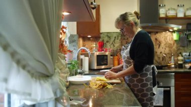  Ev hanımı evlerinin mutfağında patates soyup kesiyor. Yüksek kalite 4k görüntü