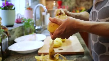  Ev hanımı evlerinin mutfağında patates soyup kesiyor. Yüksek kalite 4k görüntü